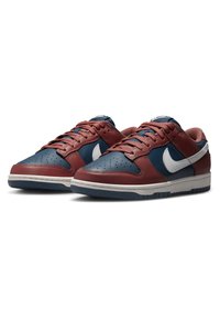 Nike Dunk-sneakers har en överdel i maroon och marinblå läder, en vit Nike-swoosh, perforerad tåkappa och en vadderad sula med en texturerad gummisula.