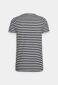 Černo-bílý pruhovaný tričko s krátkým rukávem a kulatým výstřihem, vyrobené z měkké látky, s rovnoměrnými horizontálními pruhy a volným střihem.