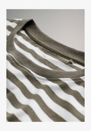 Grøn- og hvidstribet T-shirt med rund krave, blødt bomuldsstof og synligt stikningsdetalje ved halsudskæringen.