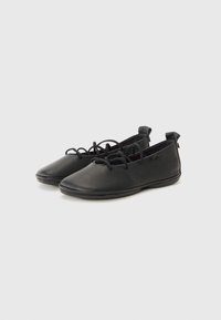 Zwarte leren schoenen met een gladde textuur, ronde neuzen en vetersluiting aan de voorkant. Beschikken over een laag profiel en een flexibele rubbersole.
