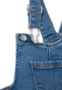 Denim tuinbroek met verstelbare blauwe banden, metalen hardware, voorzak en contrasterende stiksels. Lichtblauwe kleur met een zachte textuur.