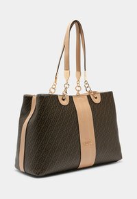 Brūna auduma soma ar gludu bēšu vertikālu svītru, zelta detaļām, divām ādas siksnām un izspiestu zīmola logotipu priekšpusē.