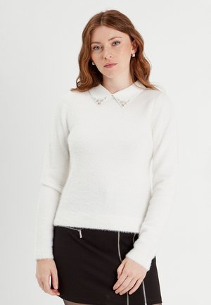 Witte fluffy trui met een kraag en versierd met glazen edelstenen. Getailleerd ontwerp met lange mouwen en geribde zoom.