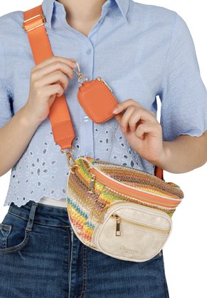 Person in blue shirt attaching small orange pouch to colorful striped crossbody bag with orange strap.