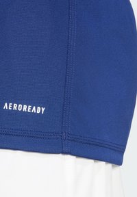 Blue atletický top AEROREADY so špeciálnou látkou odvádzajúcou vlhkosť, hladkou štruktúrou a spevneným švom na leme. Farba prechádza do bielej.