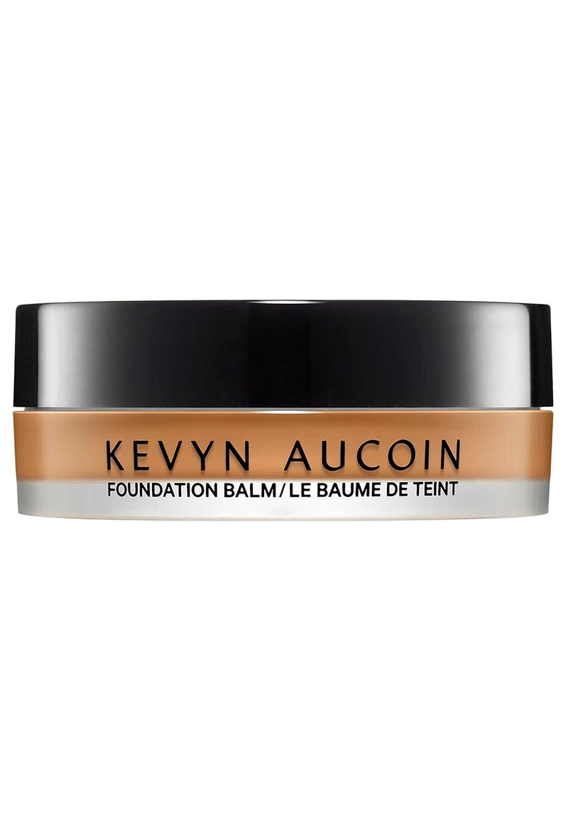 Kevyn Aucoin Foundation Balm in a round jar, featuring a matte black lid, a transparent base, and a creamy beige product visible inside.