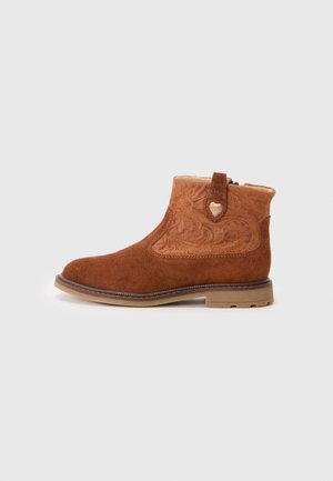 Bottines en daim marron avec une tige en cuir beige, des coutures décoratives, une languette et une semelle en caoutchouc. Présente un motif de couleur contrastée.