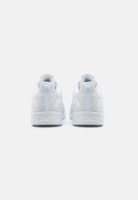 Baskets de sport blanches avec une tige en mesh texturé, un talon arrondi et un col rembourré. Présente un design minimaliste avec des branding et des accents subtils.