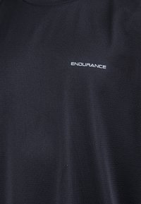 Svart atletisk t-shirt med texturerad tyg, med en vit "ENDURANCE"-logotyp på övre vänstra sidan. Klassisk rundhalsdesign.