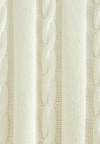 Cremfarbener gestrickter Stoff mit vertikalen geflochtenen Zopfmusterungen und strukturierten Stichdetails.