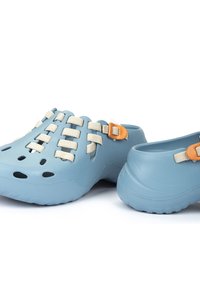 Zuecos de goma azul con un diseño perforado, correas de textil y accesorios en color naranja. Tienen suelas elevadas y un acabado flexible y texturizado.