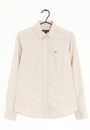 Jasnobeżowa koszula w kratę na guziki, z klasycznym kołnierzykiem, długimi rękawami, pojedynczą kieszenią na piersi oraz małym logo na kieszeni.