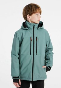 Grüne wasserdichte Jacke mit Kapuze, schwarzen Reißverschlüssen und Taschen, verstellbaren Bündchen und glatter Textur.