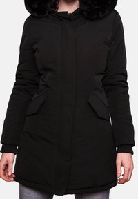 Parka noire avec une capuche en fausse fourrure, fermeture à glissière à l'avant, deux poches latérales et poignets côtelés. Texture lisse avec des détails de coutures visibles.