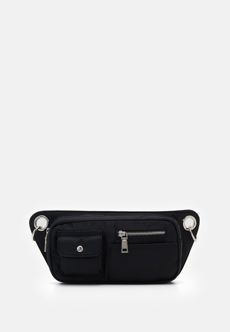 Sac banane noir avec plusieurs poches à l'avant, fermeture éclair argentée et boutons-pression, et anneaux métalliques aux deux extrémités pour fixation.