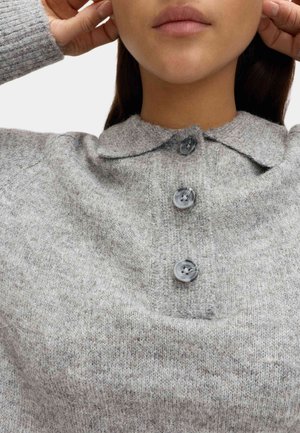 Pull gris en maille avec un col plié, une fermeture à trois boutons et un tissu texturé. Les boutons sont ronds avec une finition mouchetée.