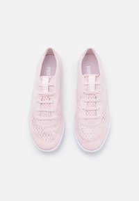 Pair of light pink Puma sports shoes with white soles and laces, featuring a breathable mesh design, viewed from above on a white background.
