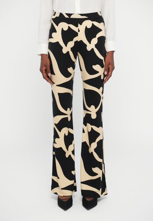 Calças flare estampadas em preto e bege, feitas de um tecido suave, com desenhos abstratos, cintura alta e um corte descontraído.