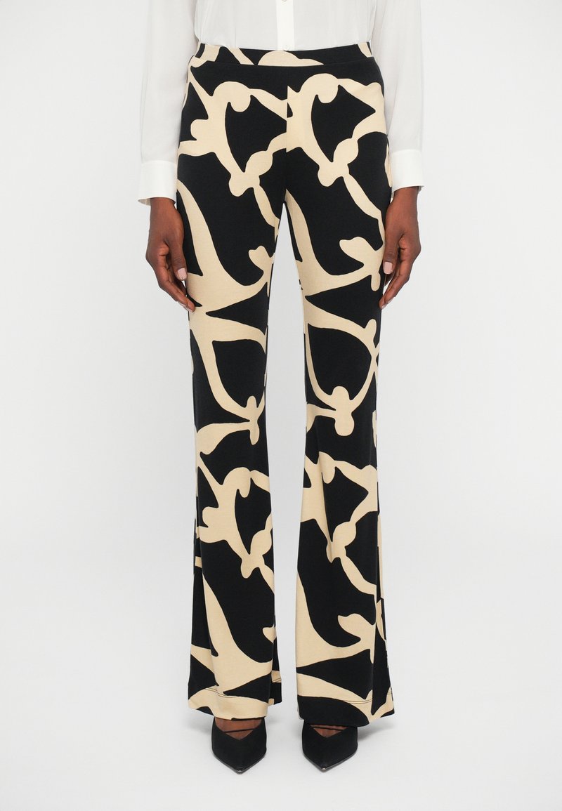 Calças flare estampadas em preto e bege, feitas de um tecido suave, com desenhos abstratos, cintura alta e um corte descontraído.