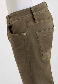 Pantalons en denim vert olive à coupe droite, dotés de poches arrière, d'une petite poche avant et de coutures contrastantes le long des coutures.
