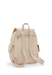 Zaino in tessuto beige con spalline regolabili, manico superiore, due tasche laterali e accessori in metallo argentato; forma rettangolare con superficie texture.