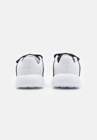 Chaussures de sport blanches et noires avec une tige en maille, un col rembourré et une semelle texturée, conçues pour le confort et le soutien.