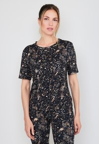 Zwart en beige atletisch shirt met een patroon, korte mouwen en een ronde hals, met een textuur die lijkt op dierenprint.