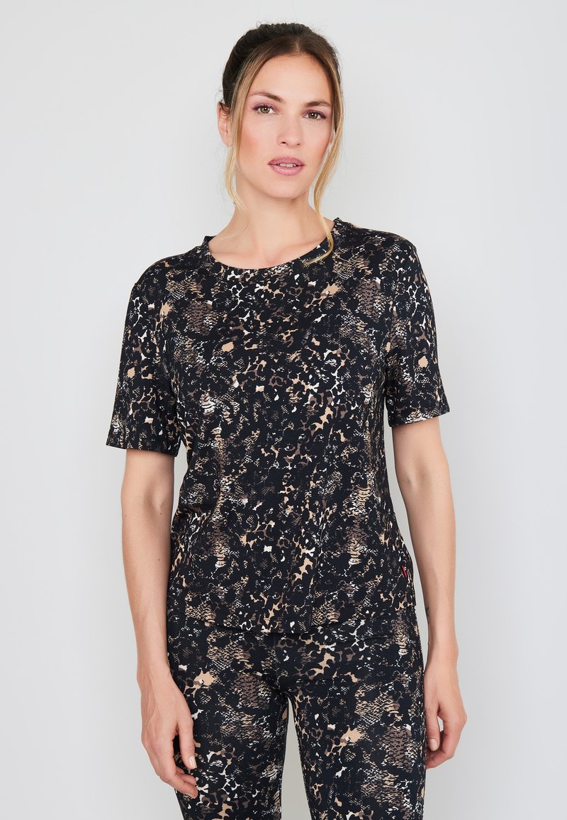 Zwart en beige atletisch shirt met een patroon, korte mouwen en een ronde hals, met een textuur die lijkt op dierenprint.