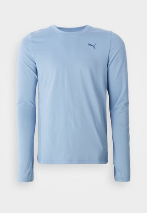 Lichtblauw langemouwen shirt gemaakt van zachte, rekbare stof. Heeft een ronde halslijn en een klein donker logo op de linkerborst.