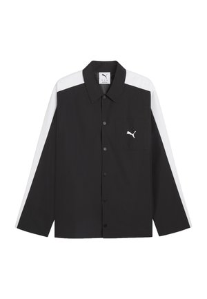 Zwarte blouse met knopen en lange mouwen met witte strepen op mouwen en schouders, met een borstzak met een wit Puma-logo.