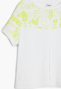 Camiseta blanca de manga corta con textura acanalada y un estampado gráfico amarillo brillante que presenta diseños y texto en la parte superior.