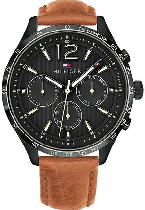 Rundes schwarzes Zifferblatt mit cremefarbenen Markierungen, drei kleineren Zifferblättern für Datum und Zeit, schwarze Lünette mit Tachymeter und braunem Lederarmband.