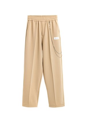 Pantalones beige de pierna ancha con cintura elástica, bolsillos laterales, pliegues delanteros y una cadena plateada decorativa unida cerca de una pequeña etiqueta blanca en el lado derecho.