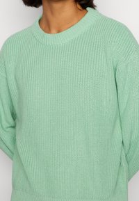 Maglione verde menta lavorato a maglia con scollatura rotonda, caratterizzato da un motivo testurizzato e polsini a costine. Materiale morbido con una vestibilità comoda.