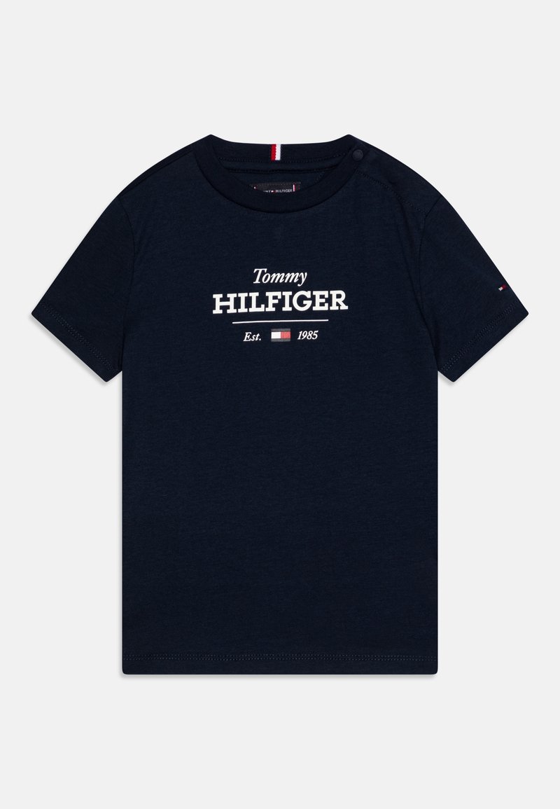 Granatowa bawełniana koszulka z krótkim rękawem, z białym napisem "Tommy HILFIGER" oraz "Est. 1985" poniżej. Zawiera mały akcent w postaci logo.