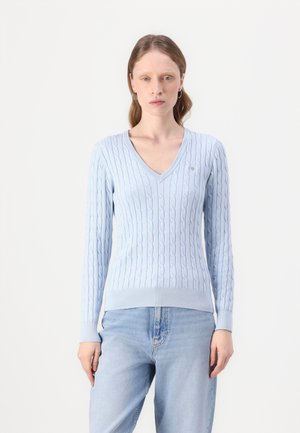 Helles blaues Strickpulli mit V-Ausschnitt, gerippten Manschetten und Saum. Verfügt über ein kleines gesticktes Logo auf der Brust.