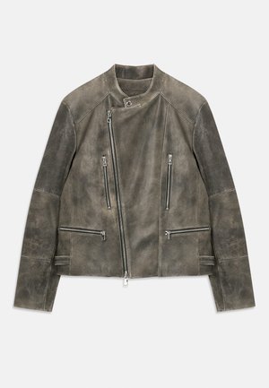 Pelēks ādas motokrekls ar stāvu apkakli, ar rāvējslēdzēju aizdari un vairākiem rāvējslēdzēja kabatām. Tekstūrēts apdare ar kontrastējošām piedurknēm.