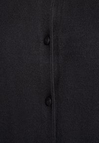 Čierny kardigán vyrobený z rebrovanej pleteniny, s predným zapínaním na okrúhle gombíky a jemným leskom.