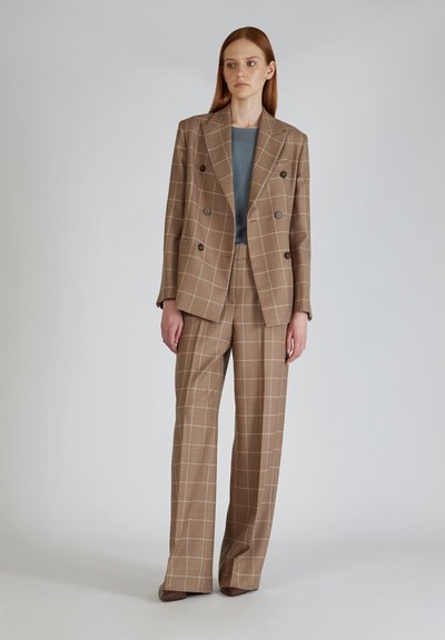 Bruin geruit dubbelgebreid blazer gecombineerd met bijpassende wijde trousers, gelaagd over een effen grijs top. Soepele stof met een getailleerde pasvorm.