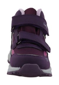 Baskets de sport violettes avec deux bandes Velcro ajustables, tige en mesh, col rembourré et semelle en caoutchouc blanc. Présente un détail d'accent rose.