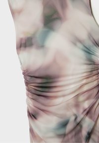 Genomskinlig, lätt tyg med ett delikat blommönster i mjuka rosa och gröna färger. Har en samlad struktur längs sidan för en extra dimension.