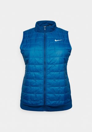 Veste sans manches matelassée bleue avec fermeture éclair sur le devant et logo Nike blanc sur la poitrine gauche, sur un fond uni clair.
