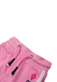 Pantalon de survêtement en coton rose avec taille côtelée, cordons noirs, œillets argentés et un motif de diamants rouges pailletés sur le côté.