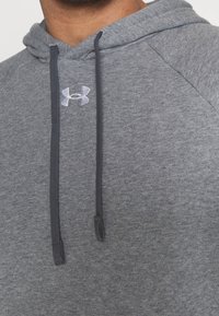 Felpa grigia realizzata in un morbido tessuto con cappuccio regolabile, dotata di un piccolo logo sul petto e cuciture piatte per una vestibilità moderna.