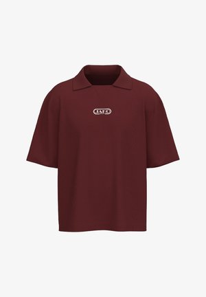 Camicia bordeaux a maniche corte con colletto e piccolo logo bianco "JAKO SPORT" centrato sul petto su sfondo bianco.