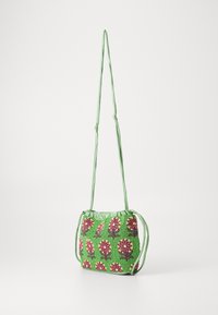 Die grüne Beuteltasche hat florale Muster in Pink und Gelb, mit einem gerafften Oberteil und einem schmalen grünen Gürtel für das Tragen als Umhängetasche.