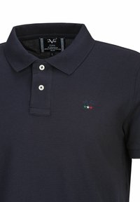 Marineblauw poloshirt gemaakt van een gestructureerde stof. Kenmerken zijn een kraag, een placket met twee knopen, en een klein geborduurd logo met drie gekleurde sterren.