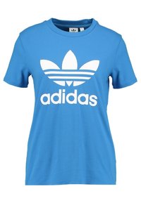 Modrá bavlněná tričko s velkým bílým logem Adidas a designem tří pruhů na přední straně, kulatým výstřihem a krátkými rukávy.