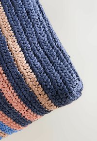 Gros plan d’un sac rectangulaire tissé à la main avec de larges rayures horizontales bleu marine, beige, rose corail et bleu clair.