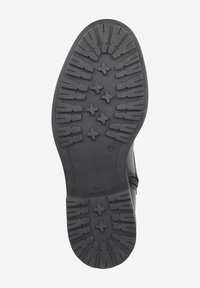 Semelle en caoutchouc noir avec des rainures profondes et un design de grip texturé. Présente une surface lisse et mate avec des bords définis et une forme de pointe arrondie.